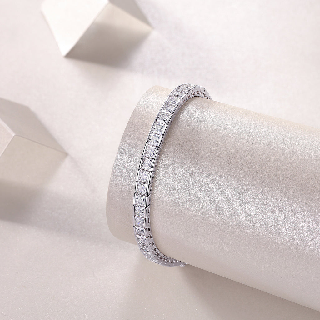 Silver bracelet with clear stones on a white satin surface