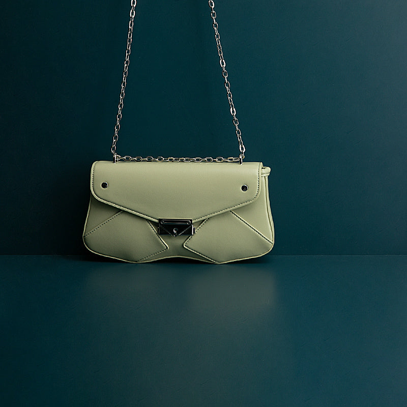 Green handbag with a chain strap on a dark green background