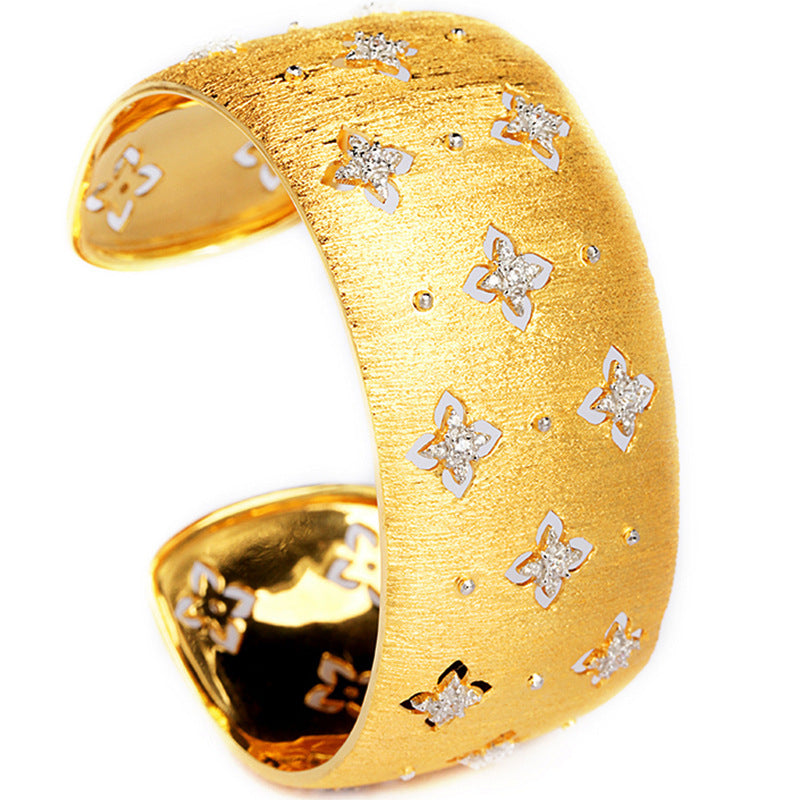 Gold bracelet with butterfly designs on a white background