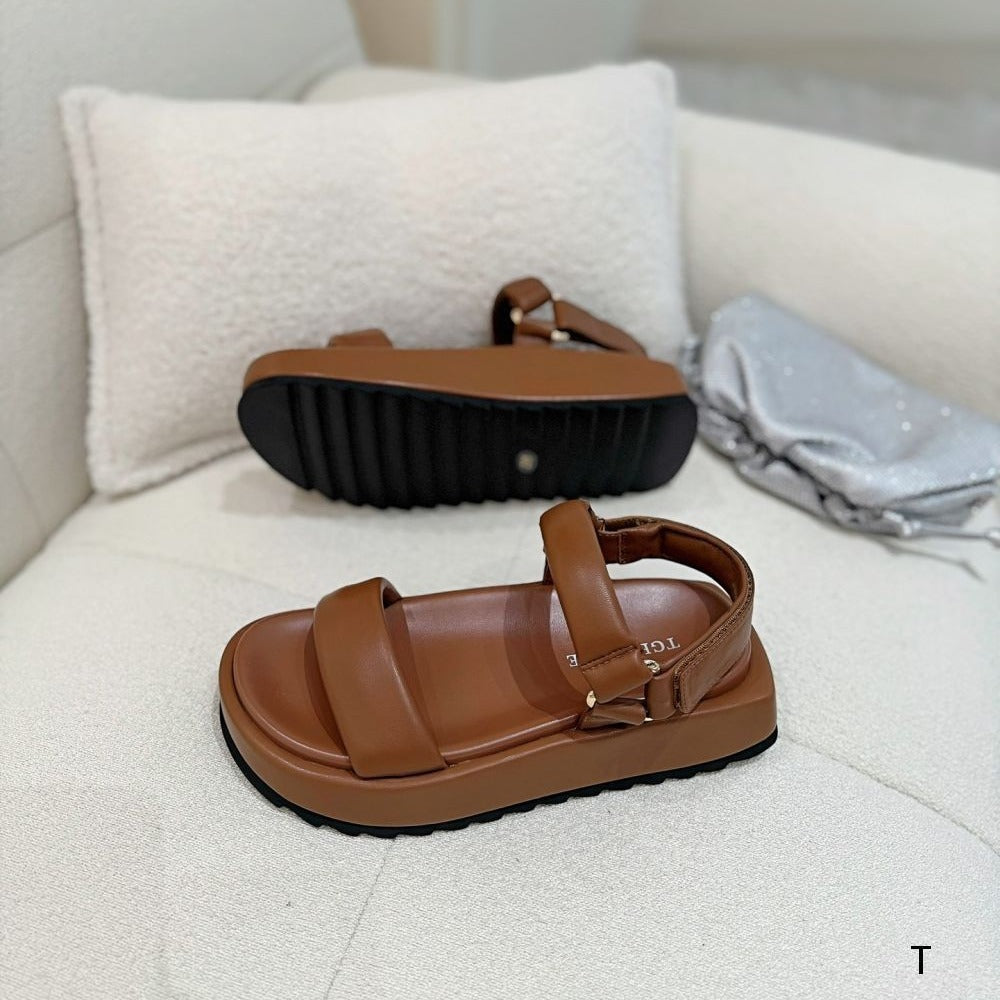 Brown sandals on a white surface with a blurred background