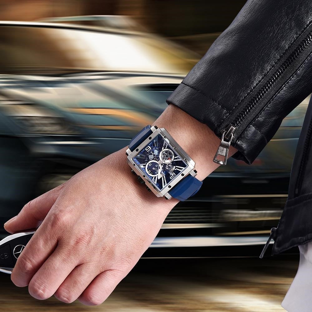 Hand wearing a blue watch with a blurred car in the background