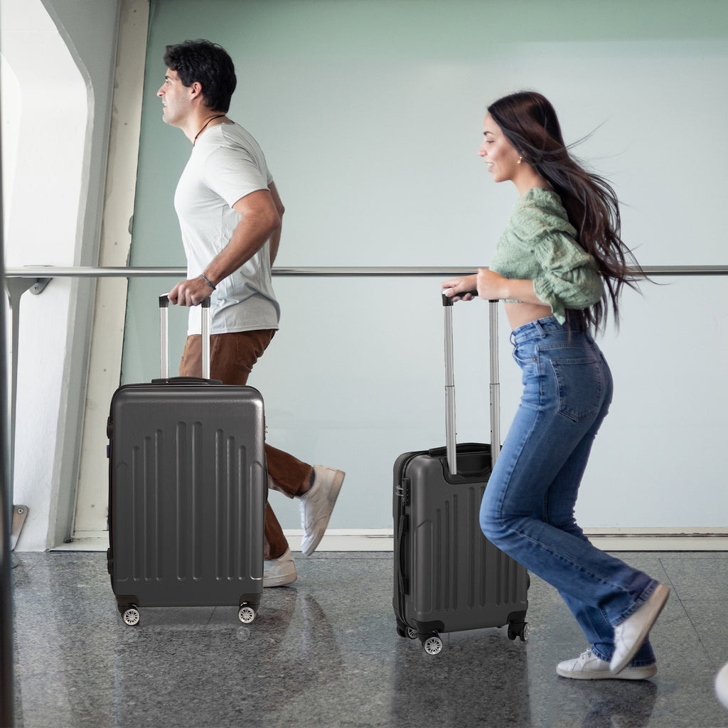 Two people with black suitcases walking in an airport.