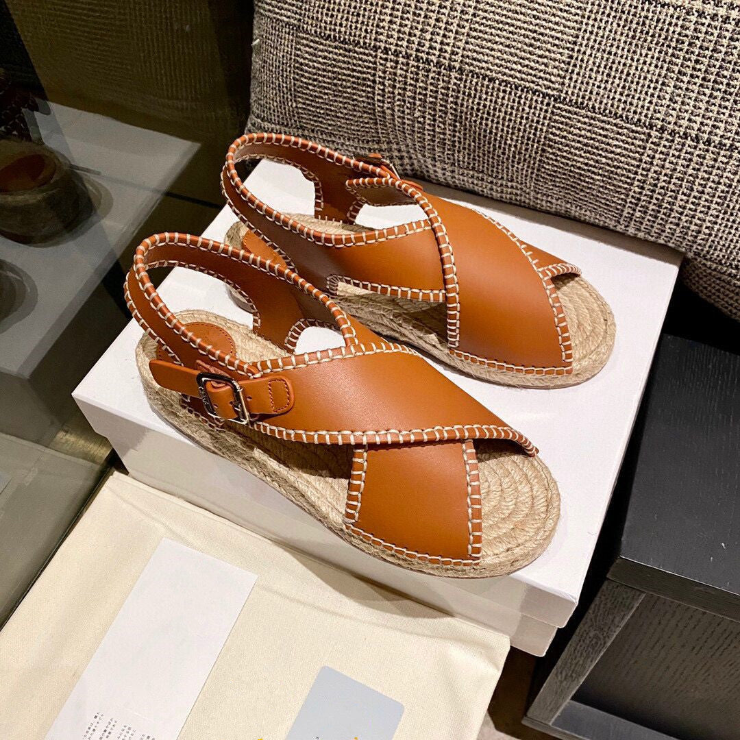 Pair of brown sandals with espadrille sole on a white box
