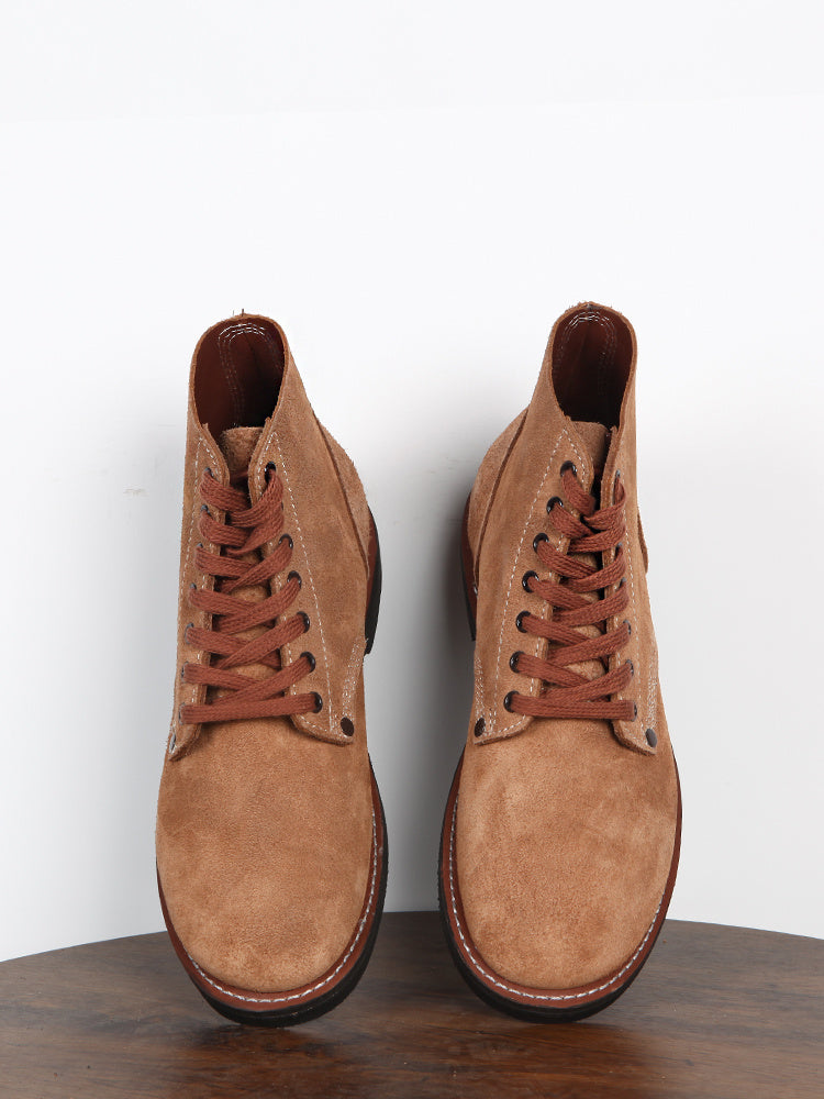 Pair of brown suede boots on a white background