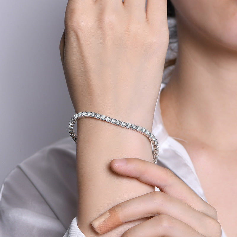 Silver bracelet on a wrist with a neutral background