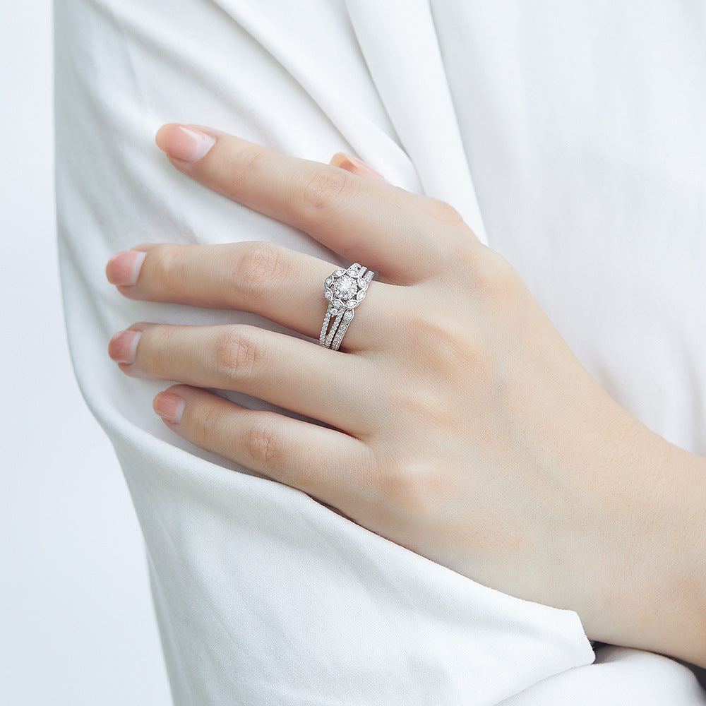Hand wearing a silver ring with a diamond on a white background