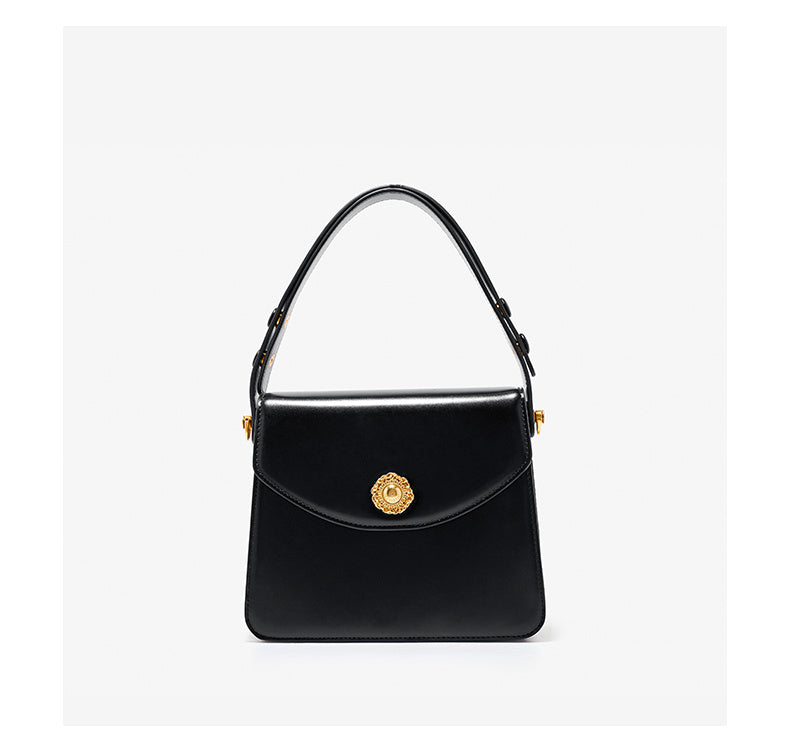 Black handbag with gold emblem on a white background