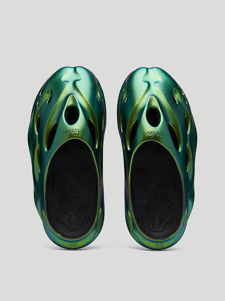 Pair of green and black sandals on a light gray background