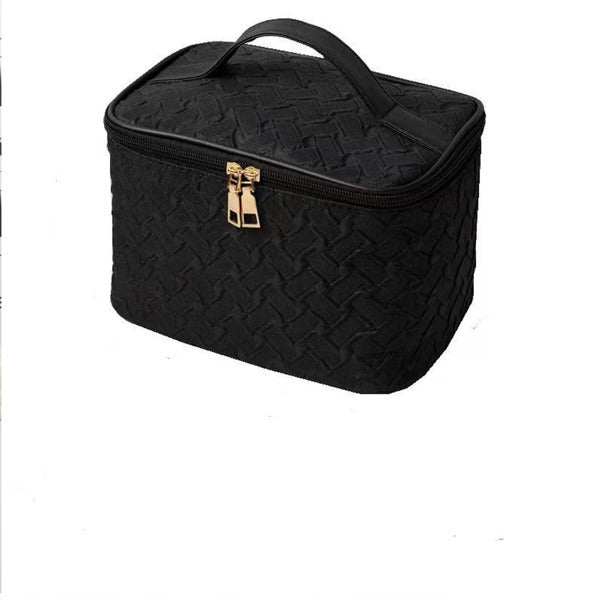 Black quilted cosmetic bag with gold clasp on a white background