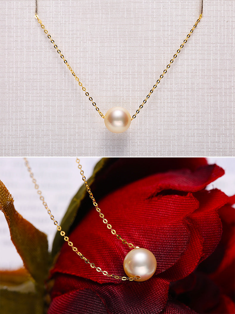 Gold necklace with a pearl pendant on a textured gray background and against a red rose.
