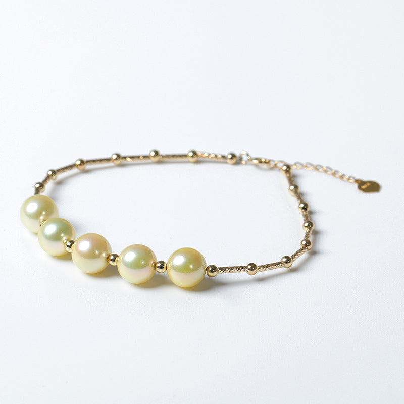 Gold bracelet with pearls on a white background