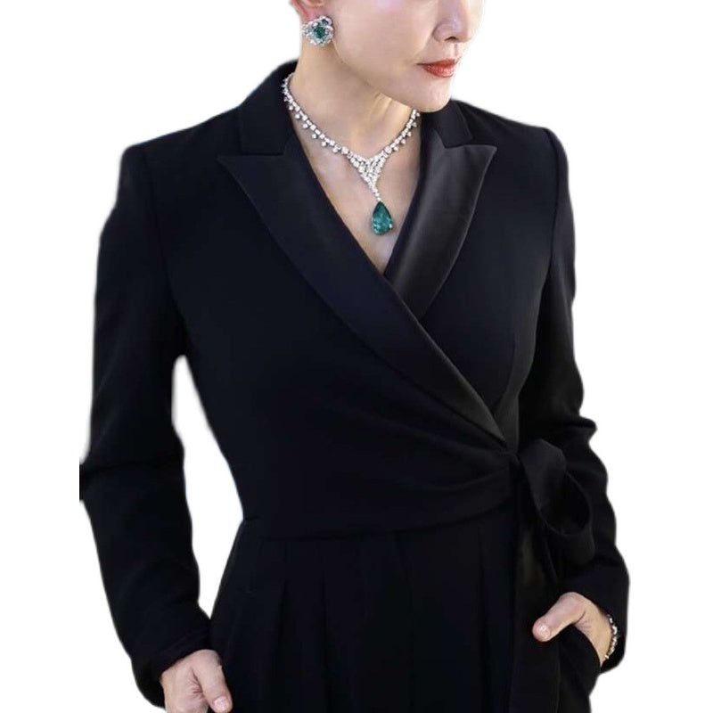 Black formal outfit with jewelry on a white background