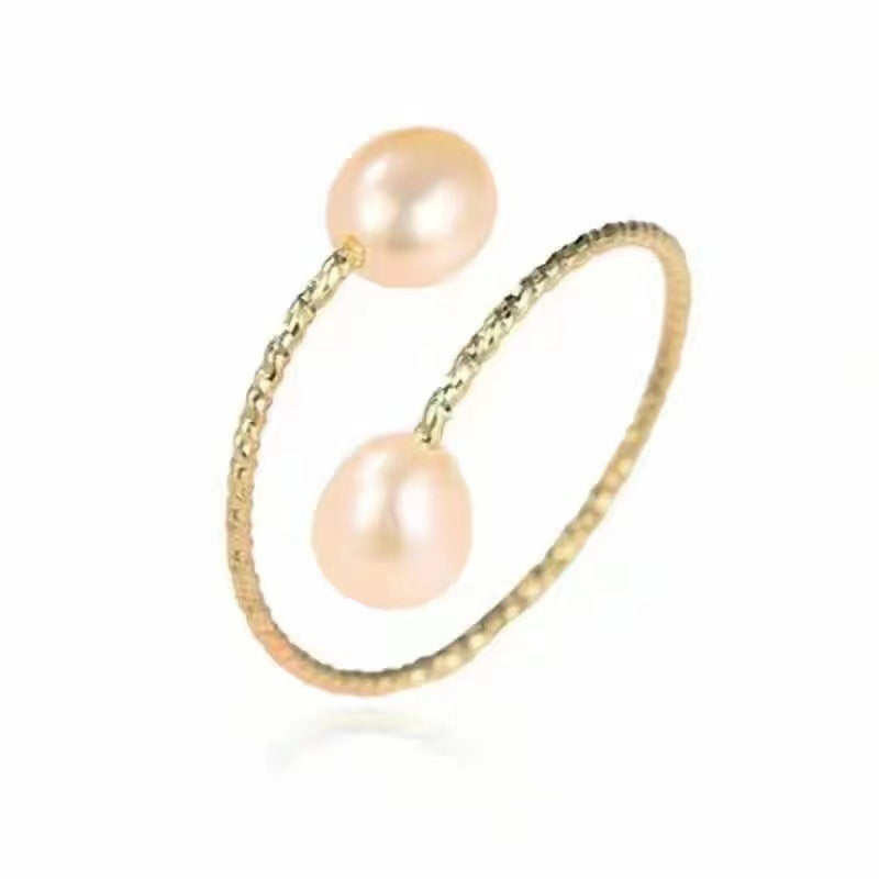 Gold ring with two pink pearls on a white background