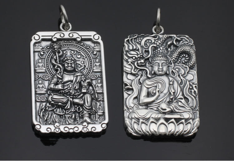 Two silver pendants with intricate designs on a dark background
