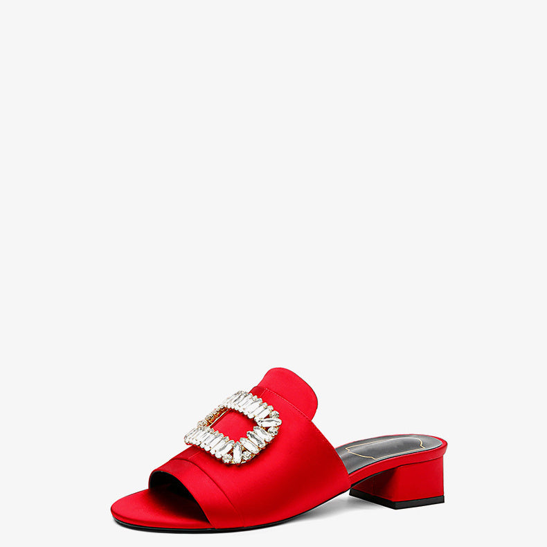 Red sandal with a decorative buckle on a white background