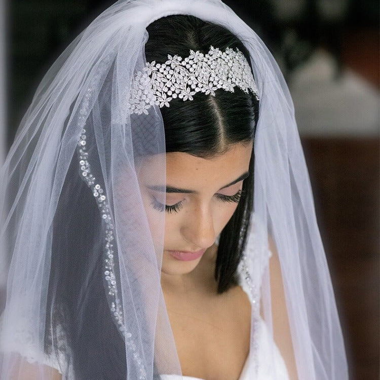 Bride wearing a veil and headpiece with a blurred background