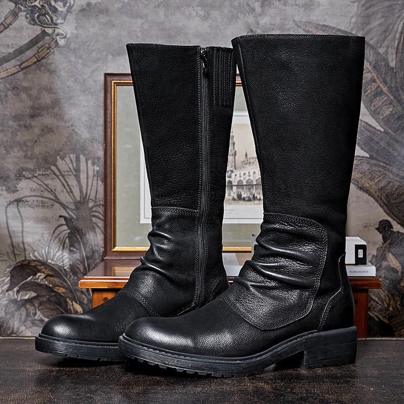 Pair of black leather boots on a textured surface with a decorative background