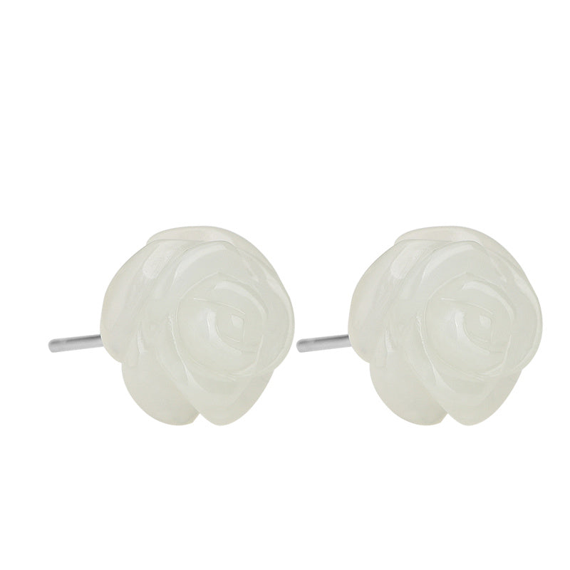 Pair of white rose-shaped stud earrings on a white background