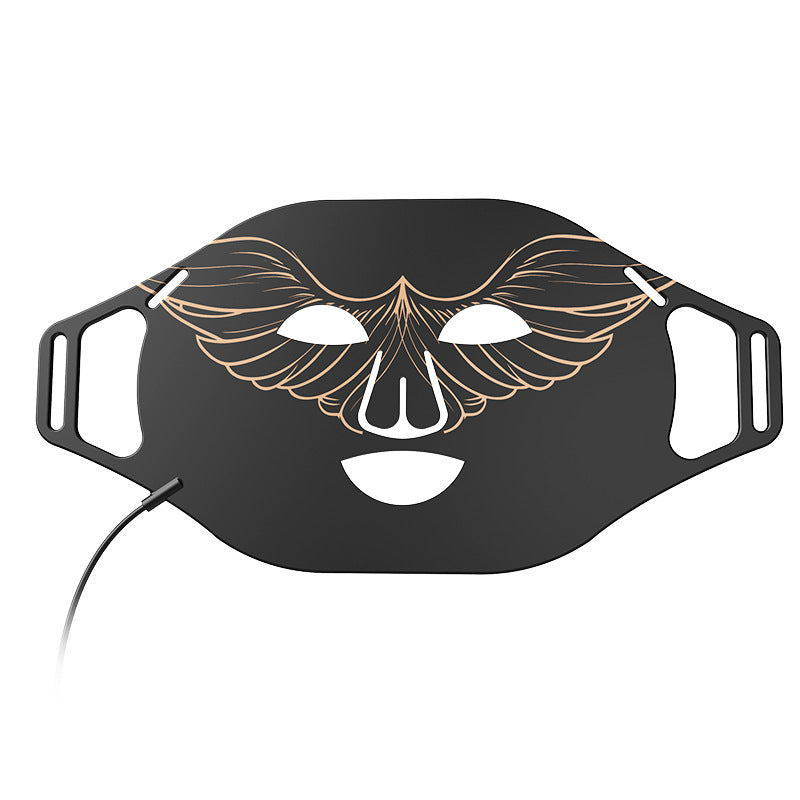 Black face mask with gold decorative design on a white background