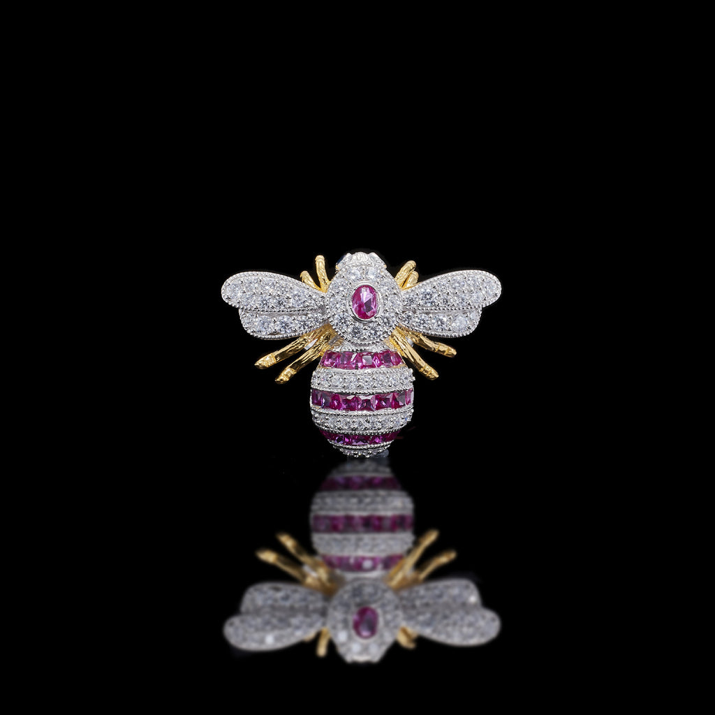 Jeweled bee brooch with pink gemstone on a black background