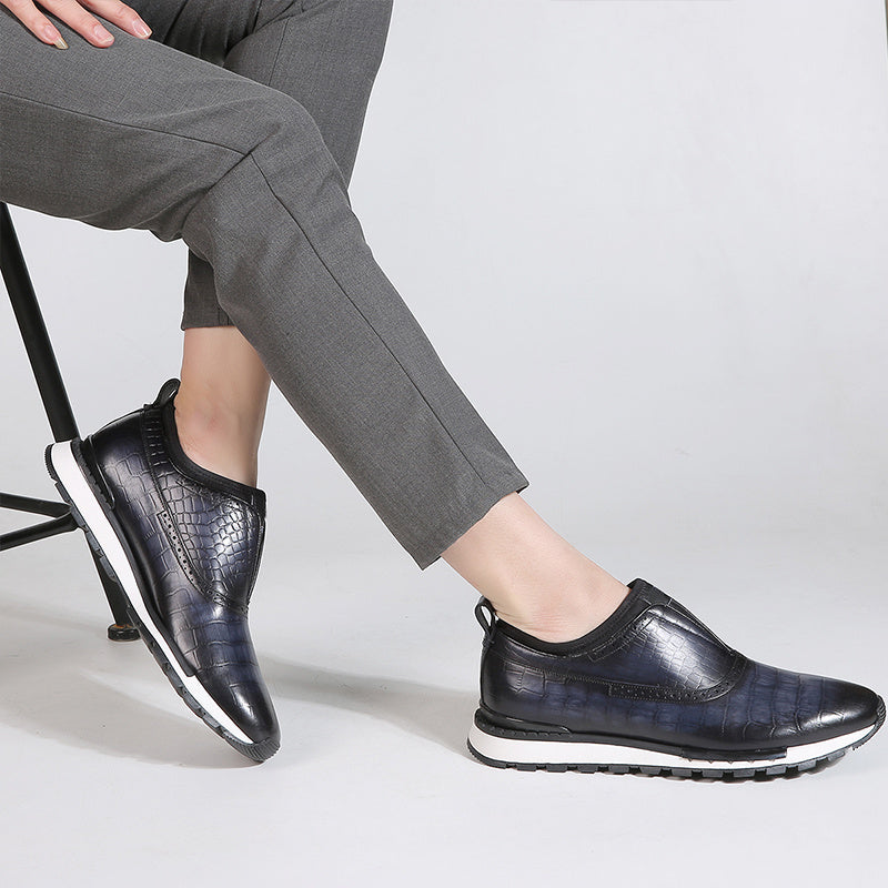 Black leather shoes worn with gray pants on a light gray background