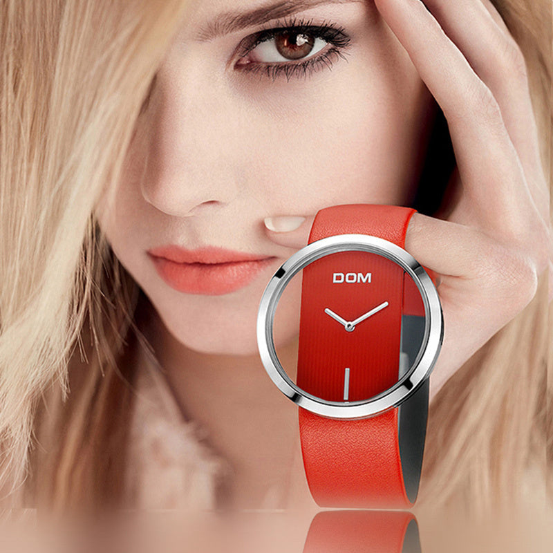 Woman wearing a red watch with 'DOM' brand on a reflective surface