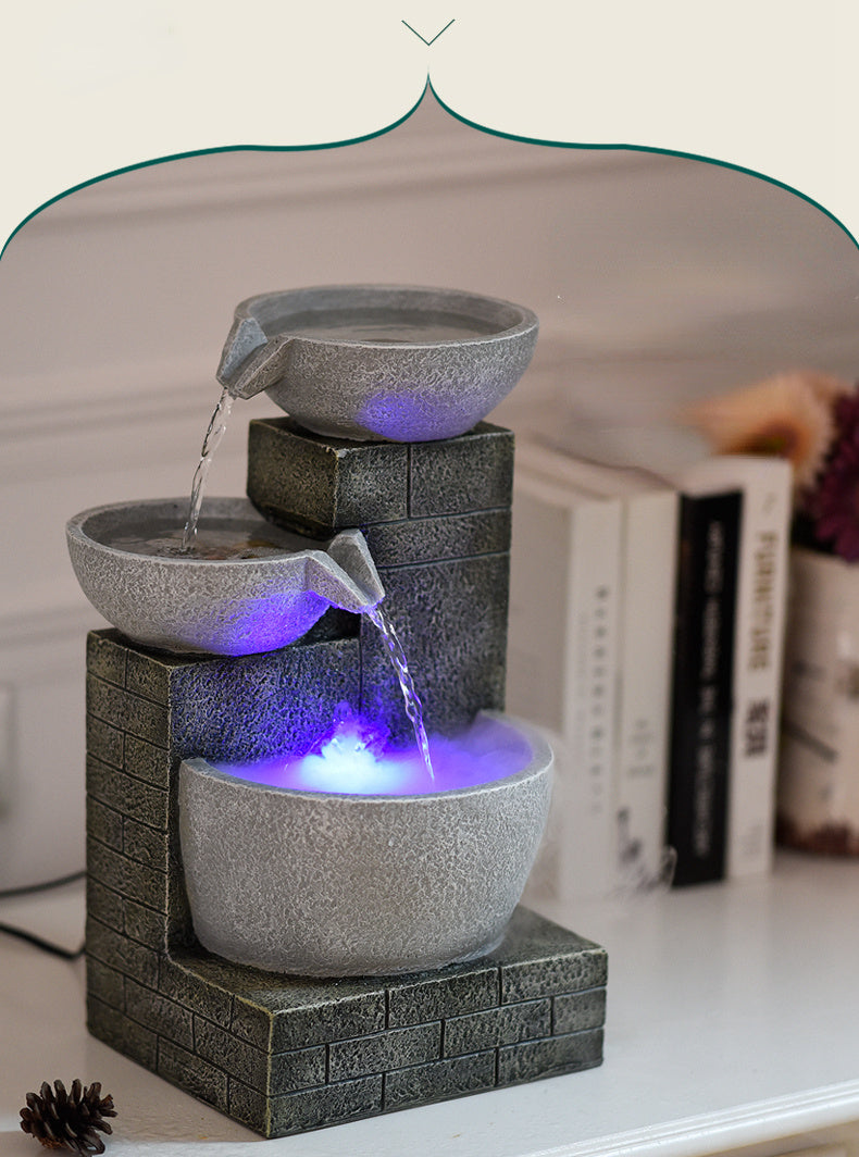 Fountain with three bowls and LED lights on a surface