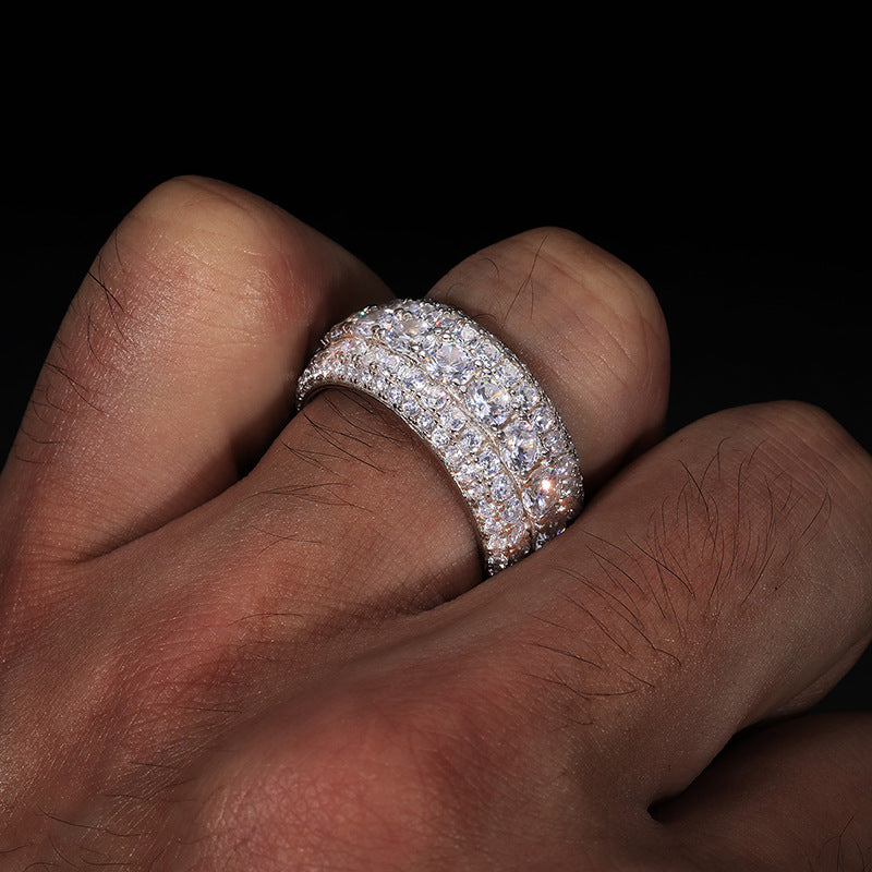 Close-up of a hand wearing a diamond ring on a dark background