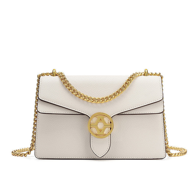 White handbag with gold chain and emblem on a white background