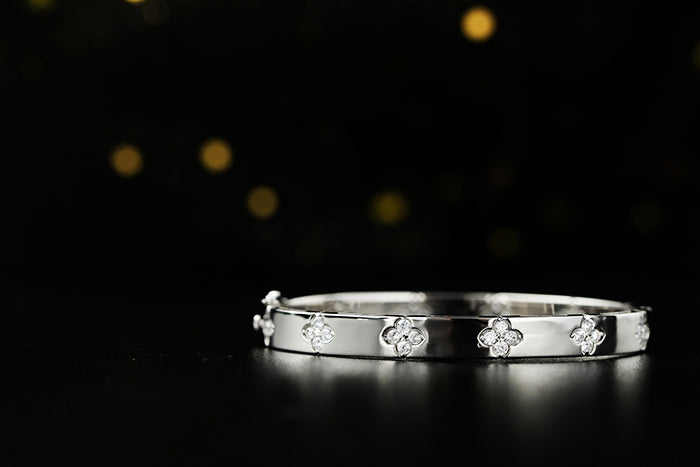 Silver bracelet with floral designs on a black background