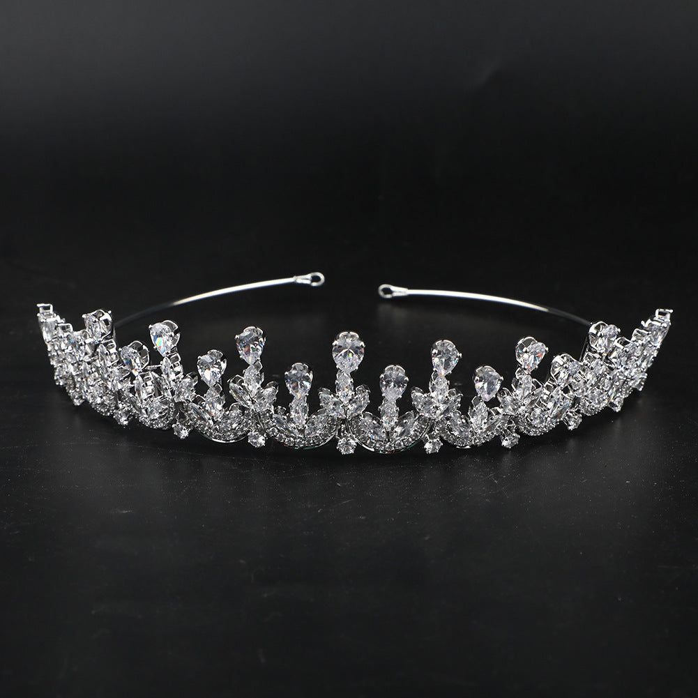 Silver tiara with clear gemstones on a black background