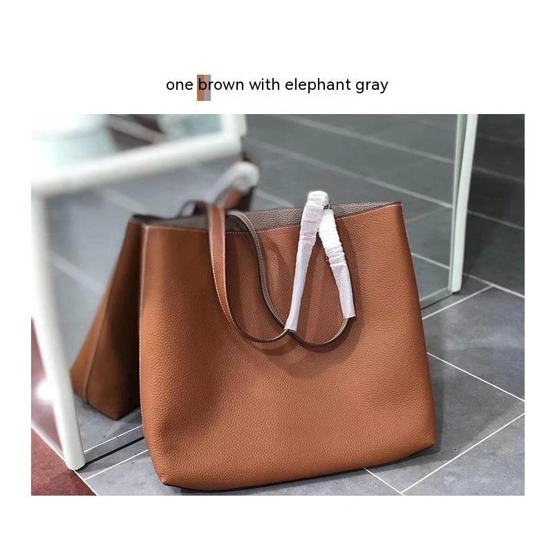 Brown handbag with white handles on a tiled floor