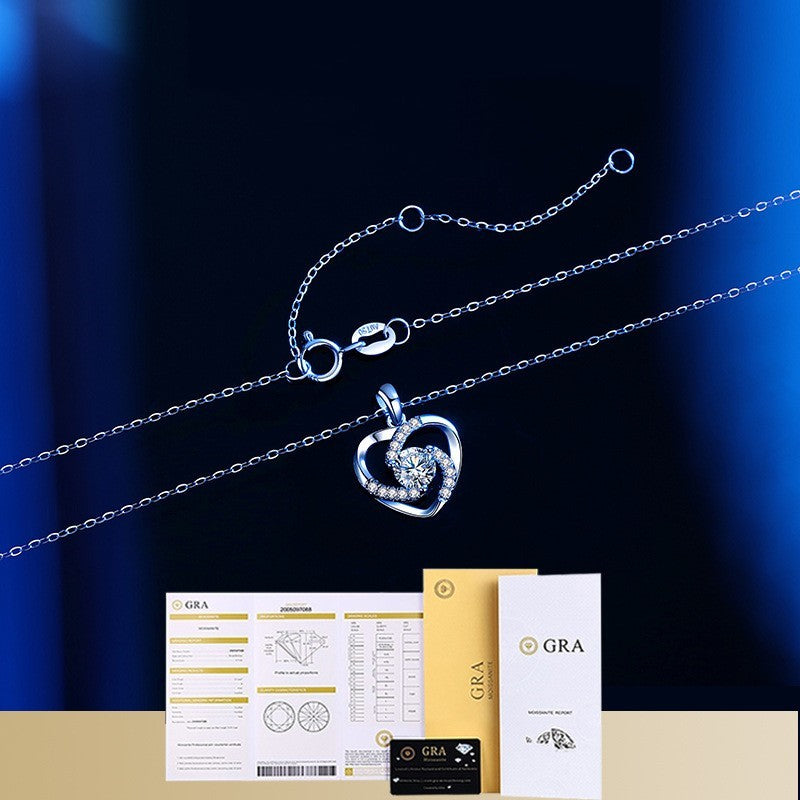 Heart-shaped silver pendant on a chain with GRA branded packaging on a dark blue background