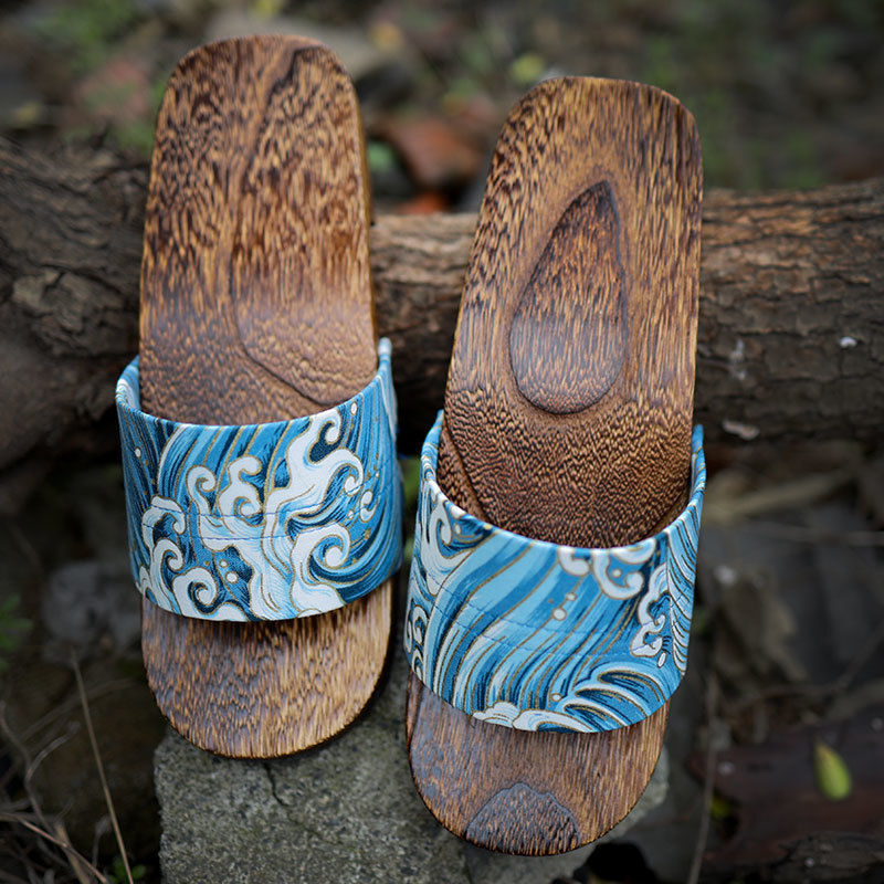 Wooden sandals with blue wave design straps on a natural background