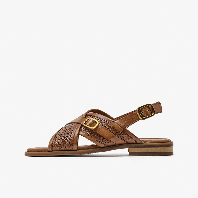 Brown sandal with a gold buckle on a white background