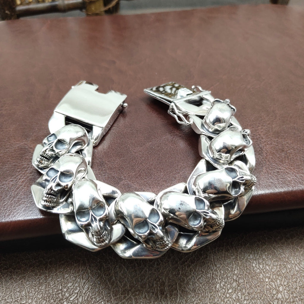 Silver skull bracelet on a brown leather surface
