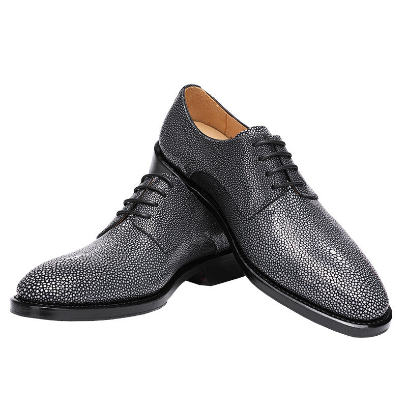Pair of black textured dress shoes on a white background