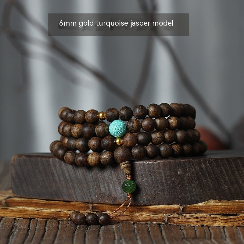 Wooden bracelet with turquoise and gold beads on a wooden surface