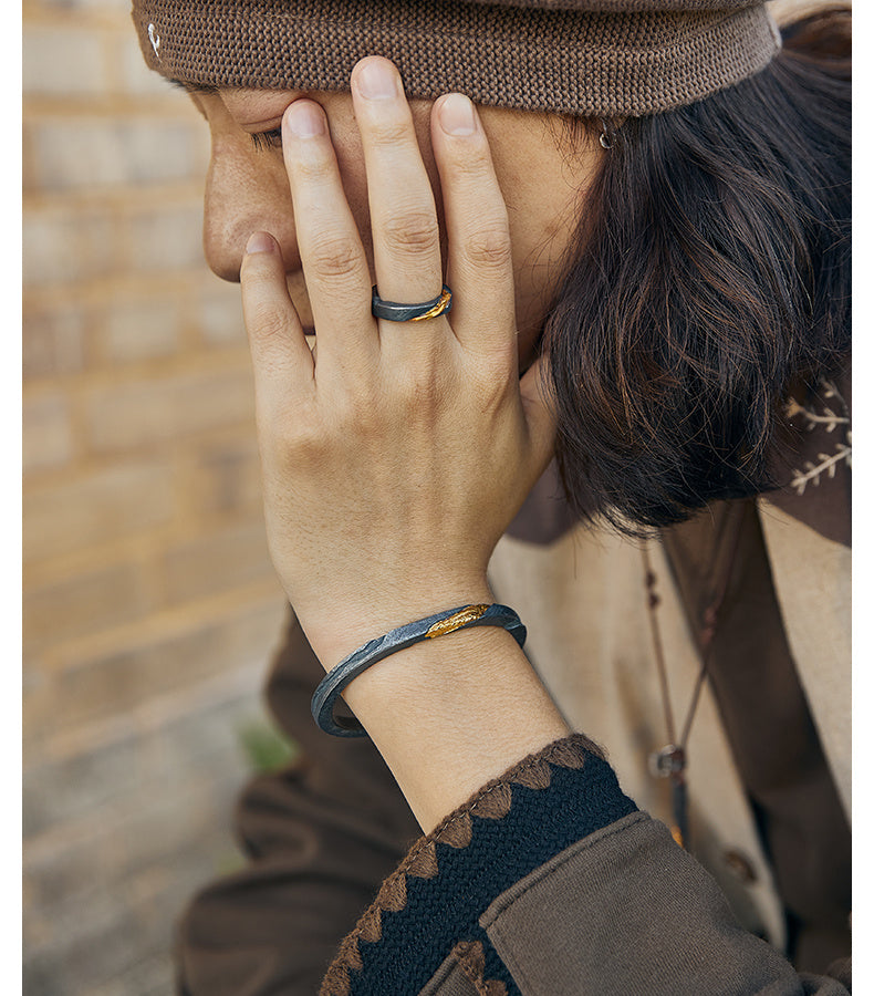 Person wearing a brown beanie and coat with a blurred brick wall background