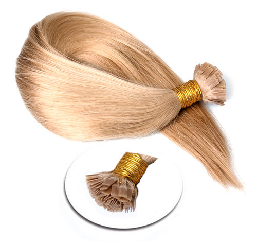 Blonde hair extensions with gold connectors on a white background