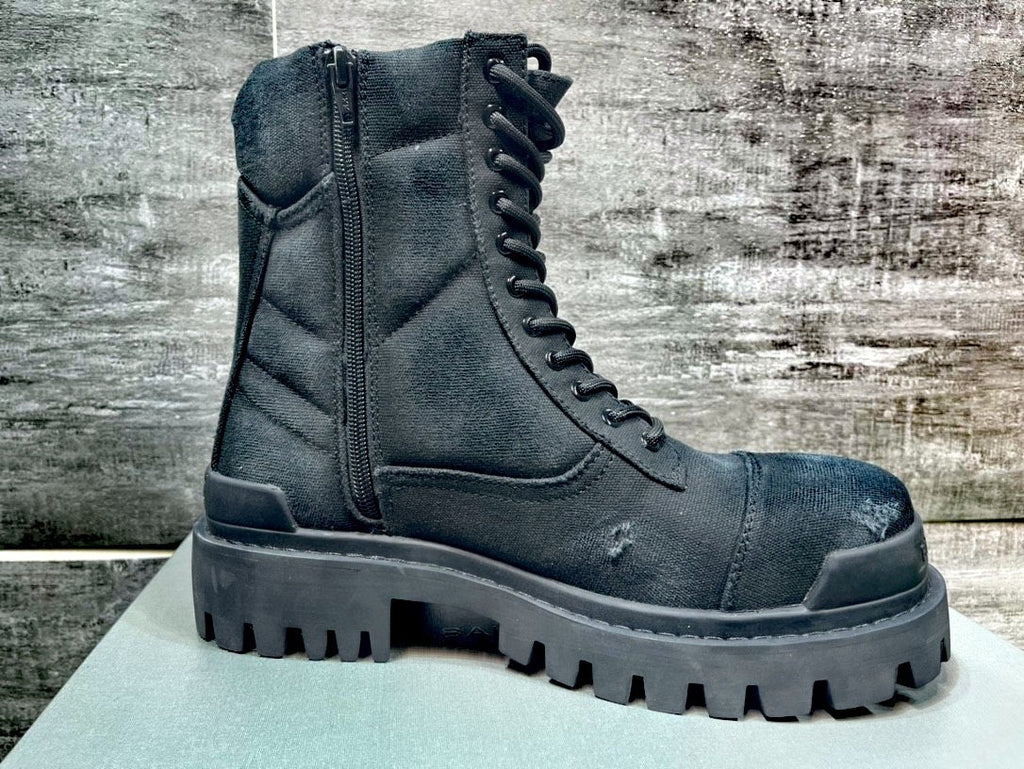 Black boot with thick sole on a wooden surface