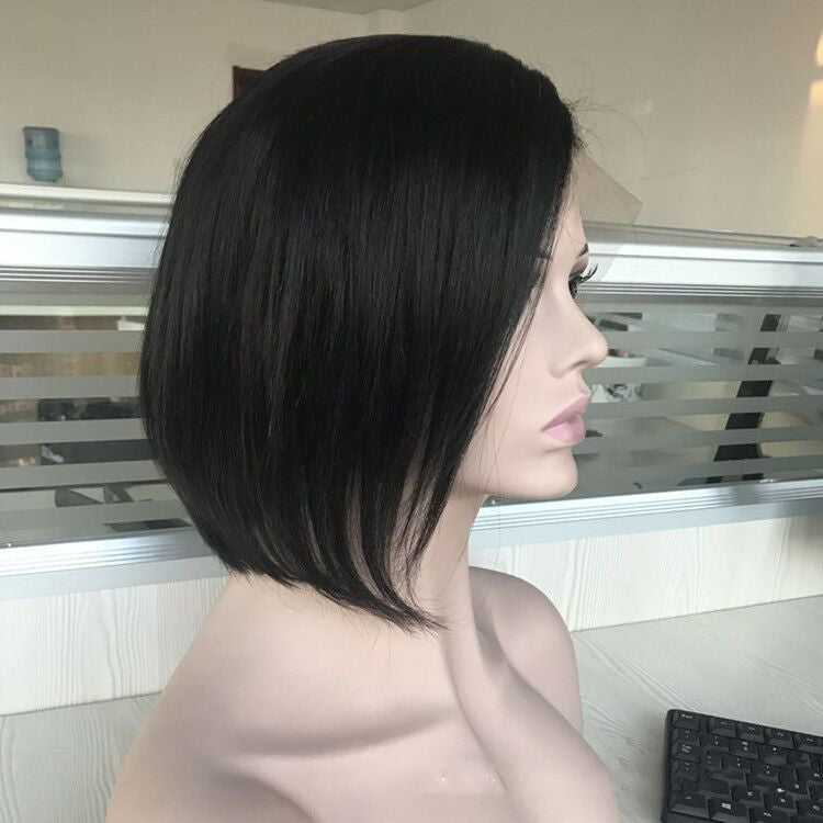 Mannequin head with black hair in front of a window