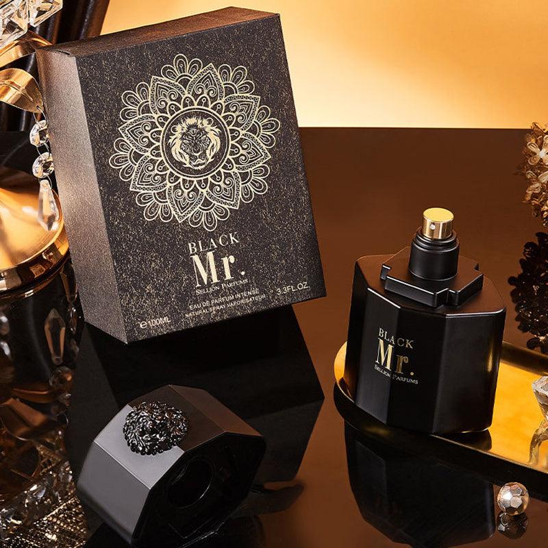 Black Mr. perfume bottle and packaging on a reflective surface with decorative elements.
