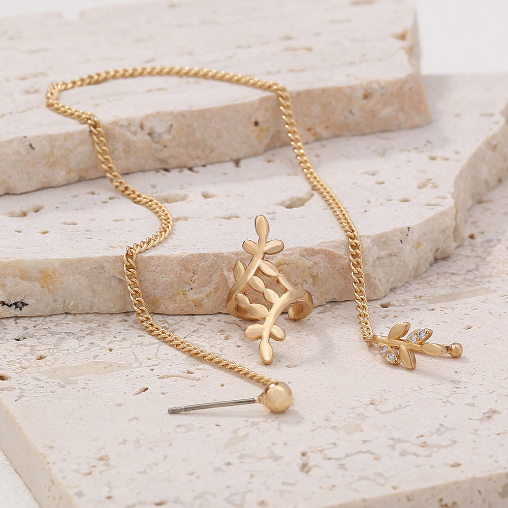 Gold necklace with a pendant on a light stone surface
