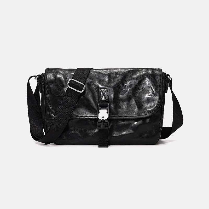 Black leather bag with a silver clasp on a light gray background