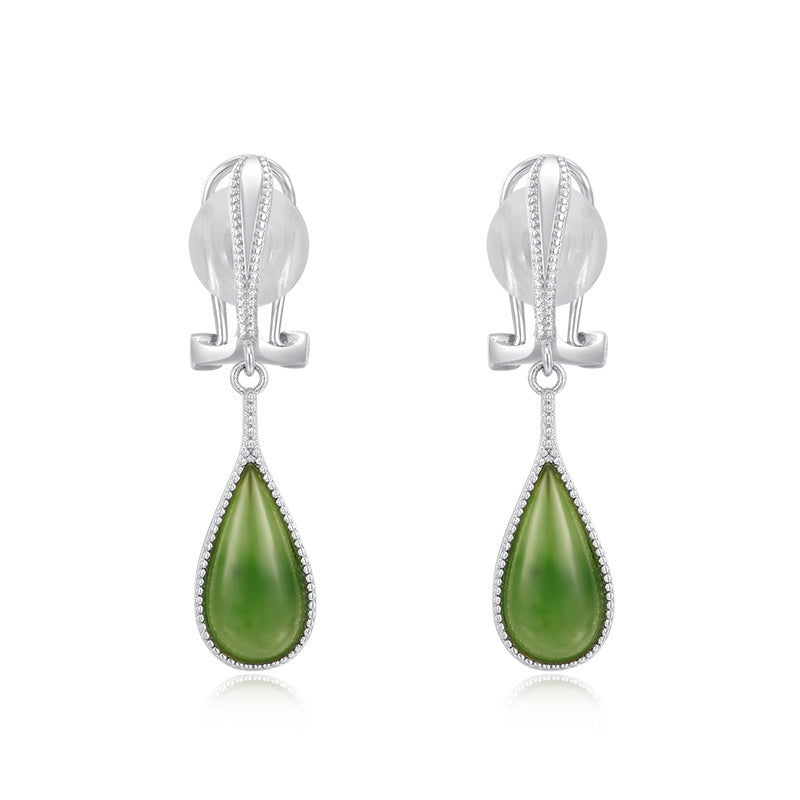 Pair of silver earrings with green teardrop stones on a white background