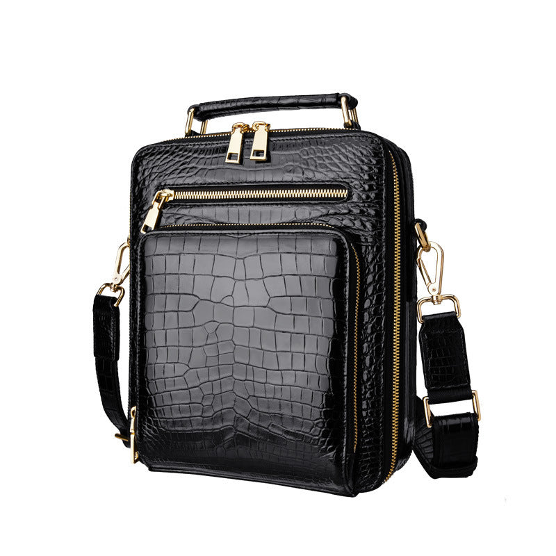 Black textured handbag with gold zippers on a white background