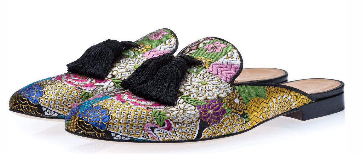 Colorful floral-patterned shoes with tassels on a white background