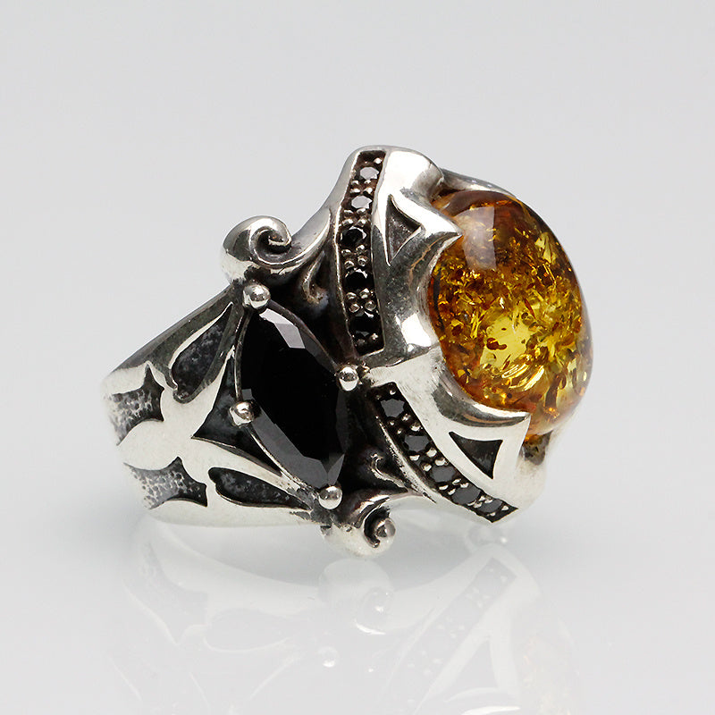 Silver ring with amber stone on a white background