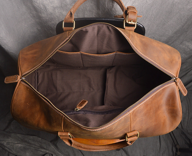 Brown leather bag with gold zipper on a gray background